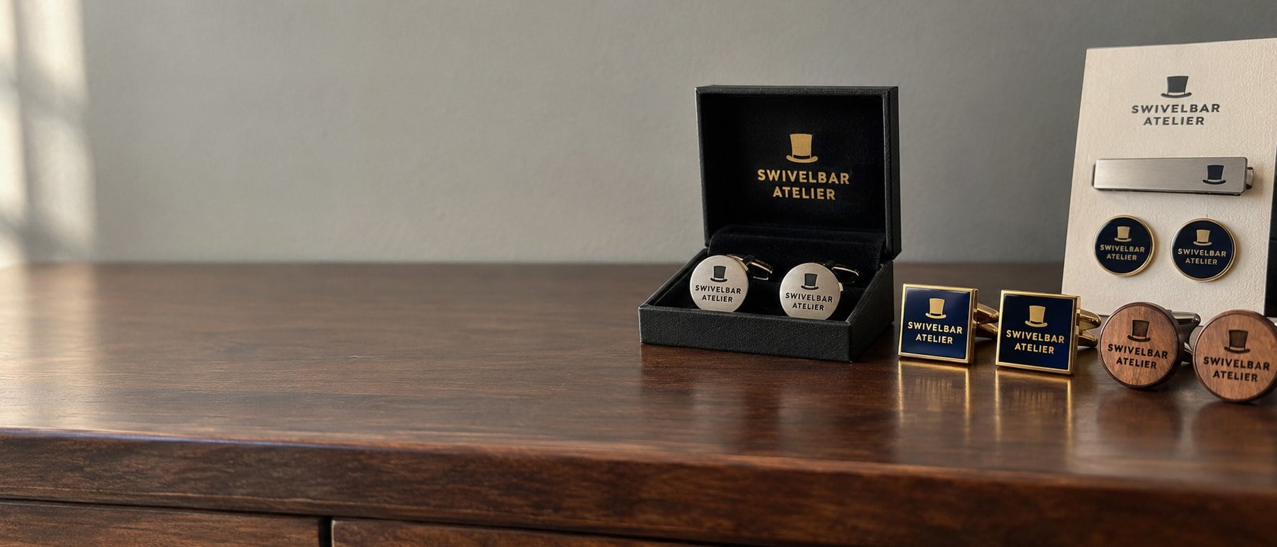 Custom engraved and enamel cufflinks in gift boxes on a walnut dresser